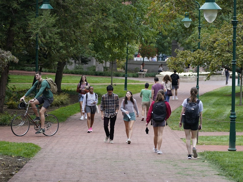 caption: Students walk to and from classes on the Indiana University campus, Thursday, Oct. 14, 2021, in Bloomington, Ind. Indiana will tax student debt relief as income, reflecting similar policies in other U.S. states following the Biden administration's announcement of a forgiveness plan in August 2022.