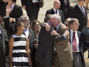 caption: Jim Obergefell and fellow plaintiff Luke Barlowe hug as they exit the Supreme Court on April 28, 2015 after oral arguments concerning whether same-sex marriage is a constitutional right.
