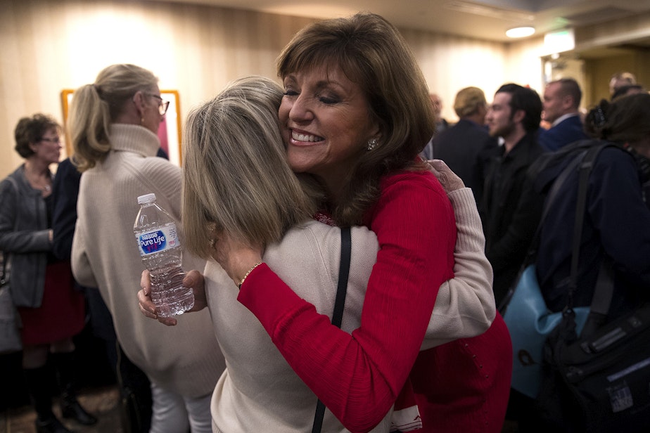caption: Susan Hutchison, right, hugs Polly Pearson on Tuesday, November 6, 2018, at the Hilton Garden Inn in Issaquah. 