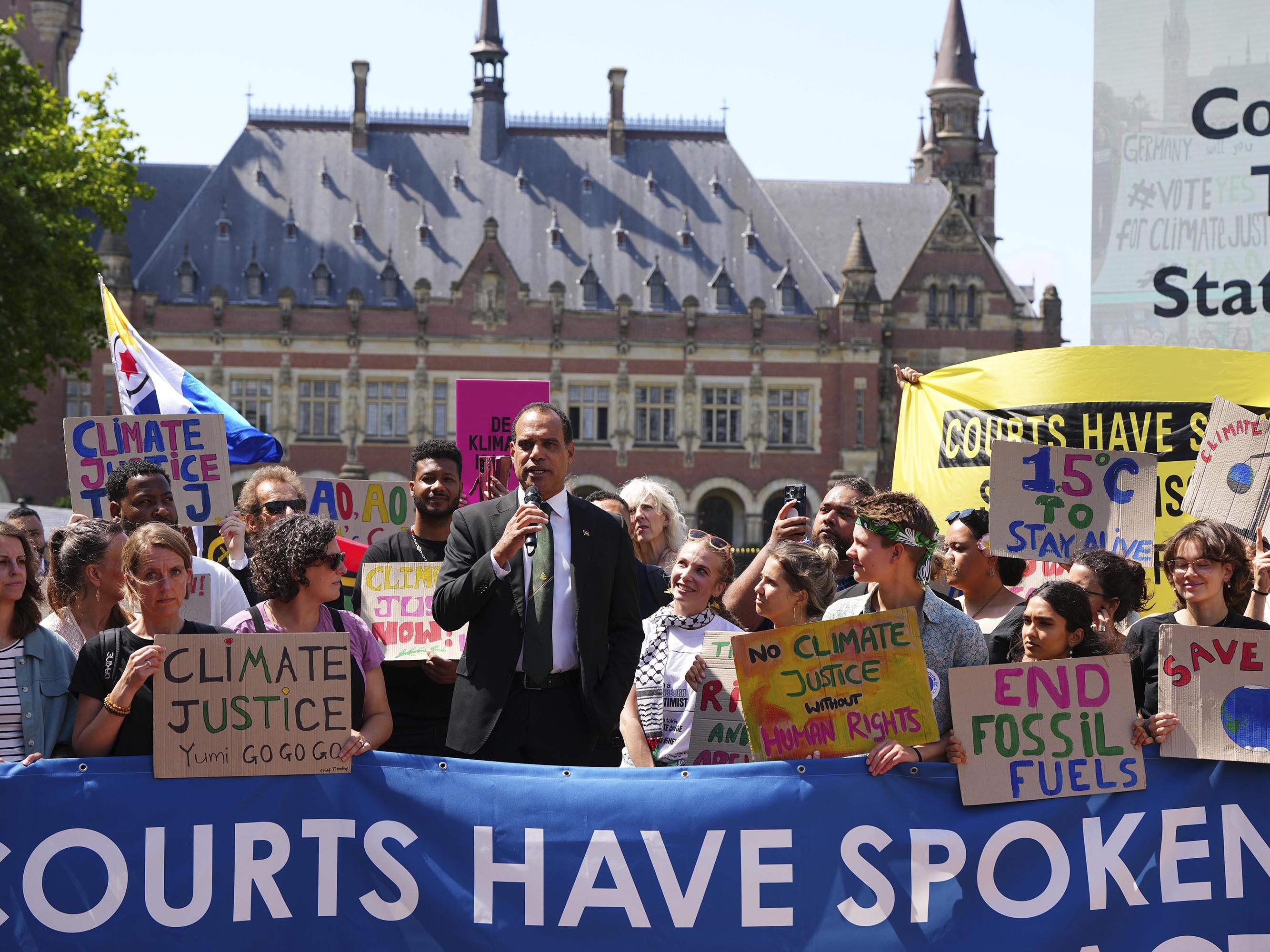 caption: Ralph Regenvanu, Vanuatu's minister for climate change, is joined by climate activists at the International Court of Justice on Wednesday. The country pushed for years for the court to hear its first major climate change case.
