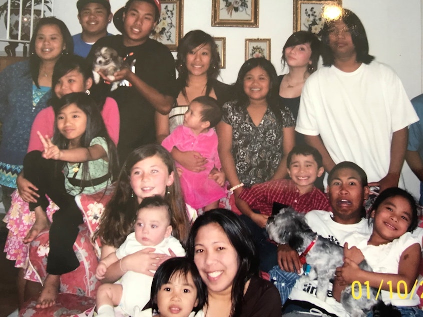 caption: A childhood photo of the author (bottom right) at a party with her family in Chula Vista, California. She remembers Chula Vista as a "Filipino bubble."