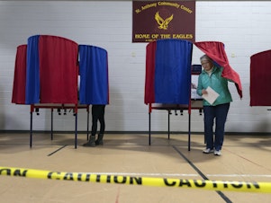 caption: A voter leaves a polling booth at St. Anthony Community Center in Manchester, N.H., during the state's presidential primary on Jan. 23.