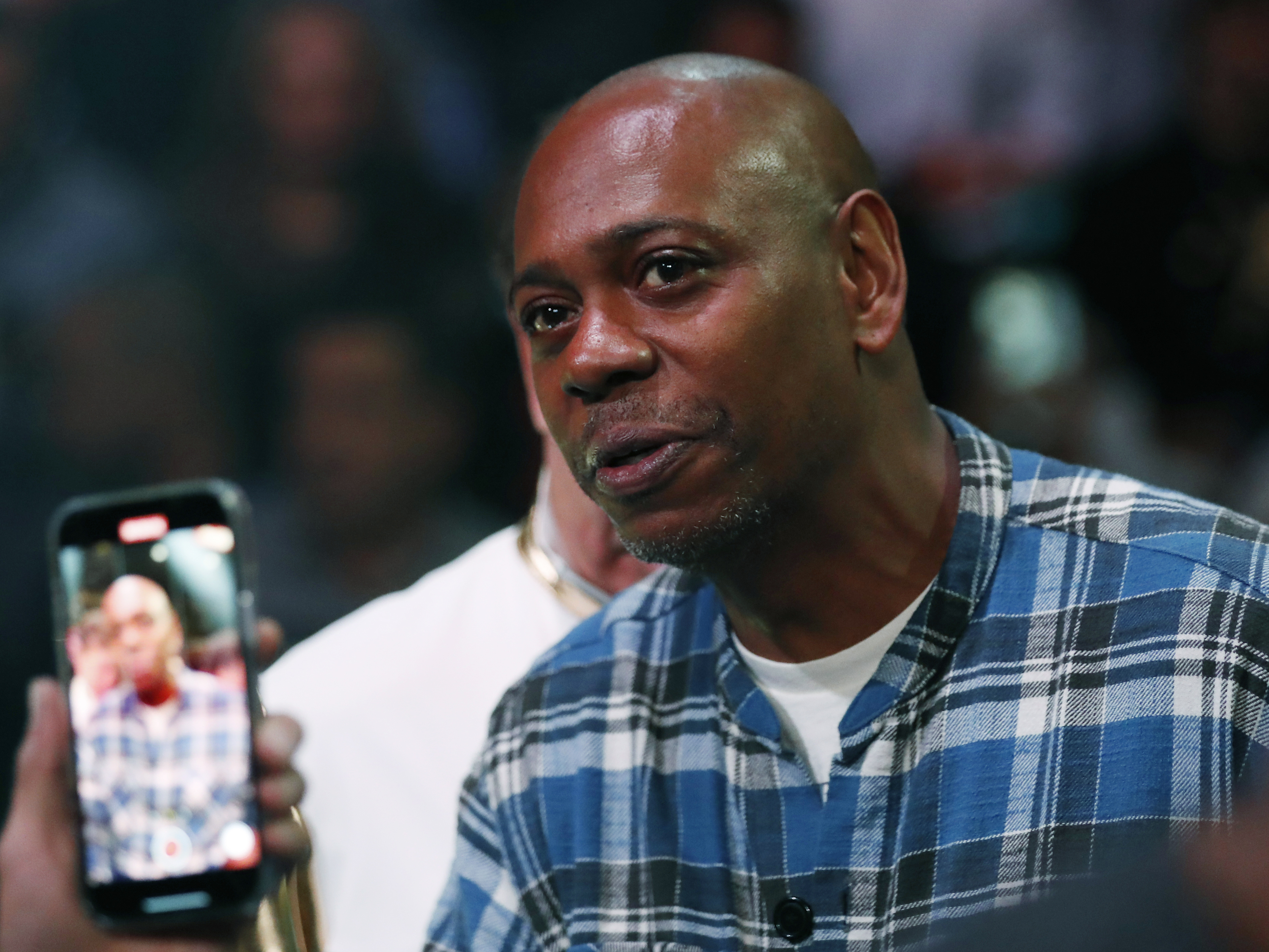 caption: Comedian Dave Chappelle attends a boxing bout Nov. 6, 2021, in Las Vegas.