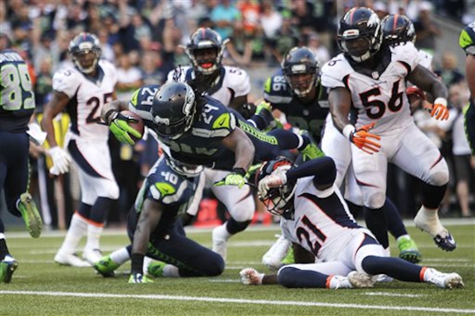 caption: Seattle Seahawks running back Marshawn Lynch dives in for the game-winning touchdown in overtime of an NFL football game against the Denver Broncos on Sunday in Seattle. The Seahawks defeated the Broncos 26-20.
