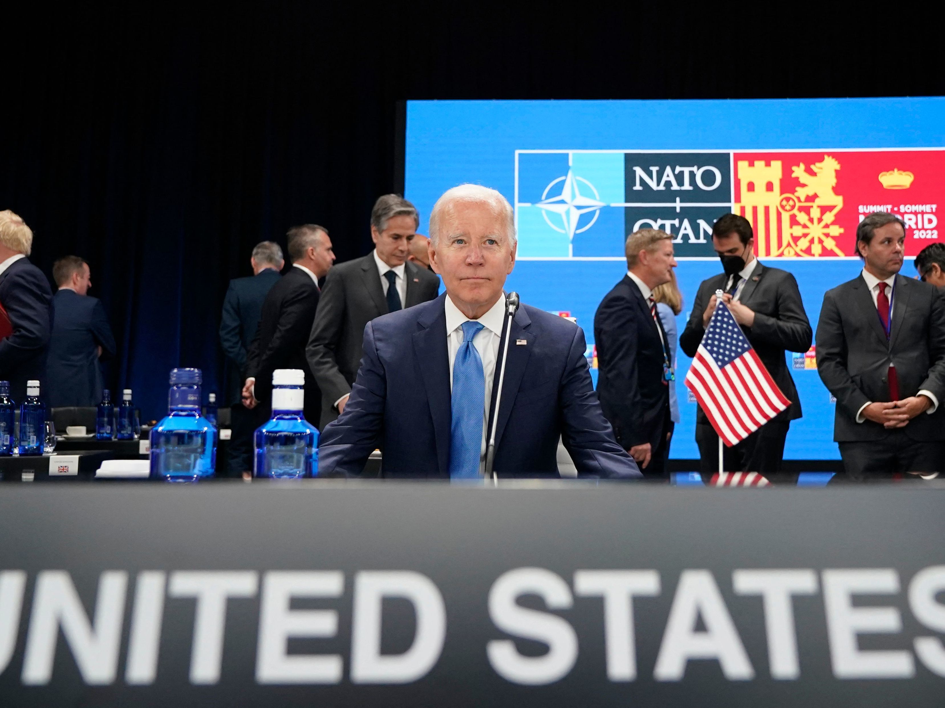 caption: President Biden waits for the start of a roundtable meeting at the NATO summit in Madrid. He announced the U.S. would increase its military presence in Europe.