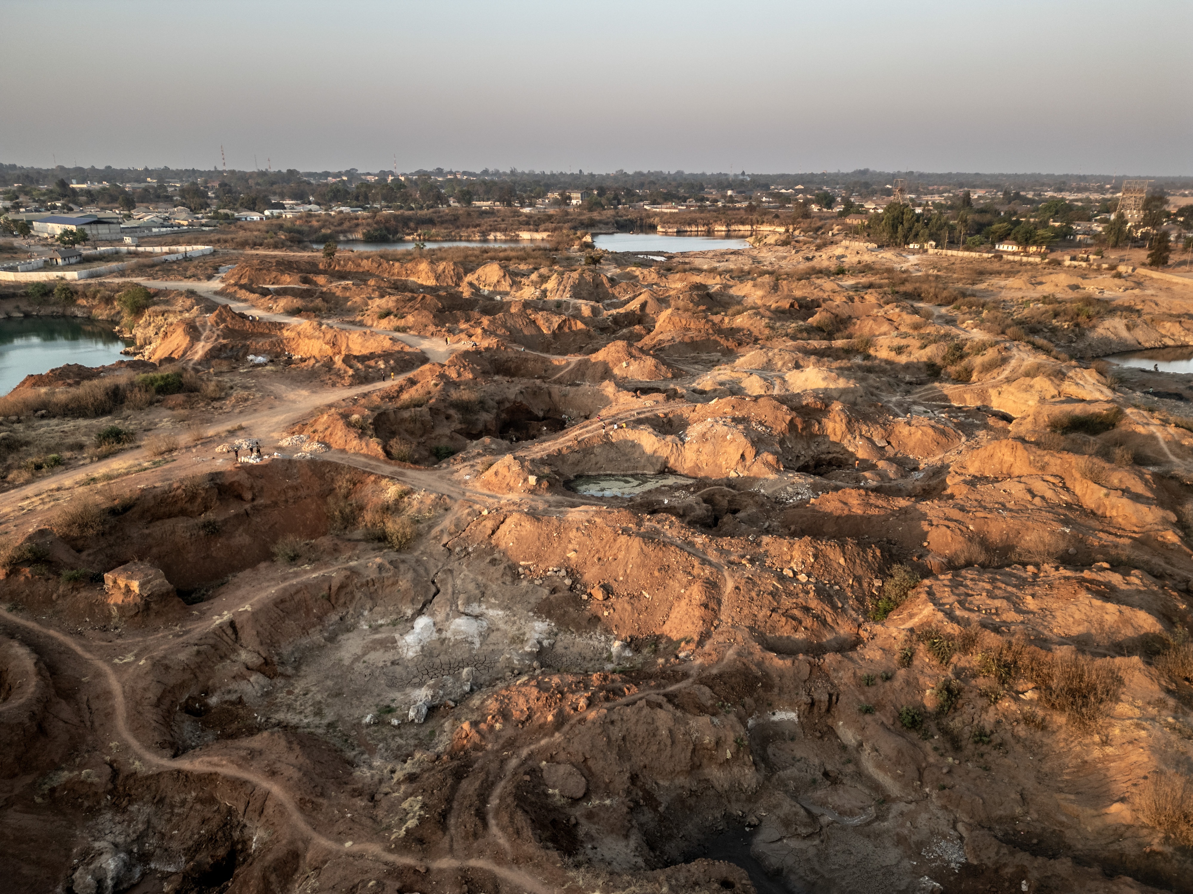 caption: The site of a former lead and zinc mine in Kabwe, Zambia. Thirty years after the closure of the mine, the land remains highly contaminated — and artisanal miners continue to work here, exposing themselves daily to dangerously high levels of lead.