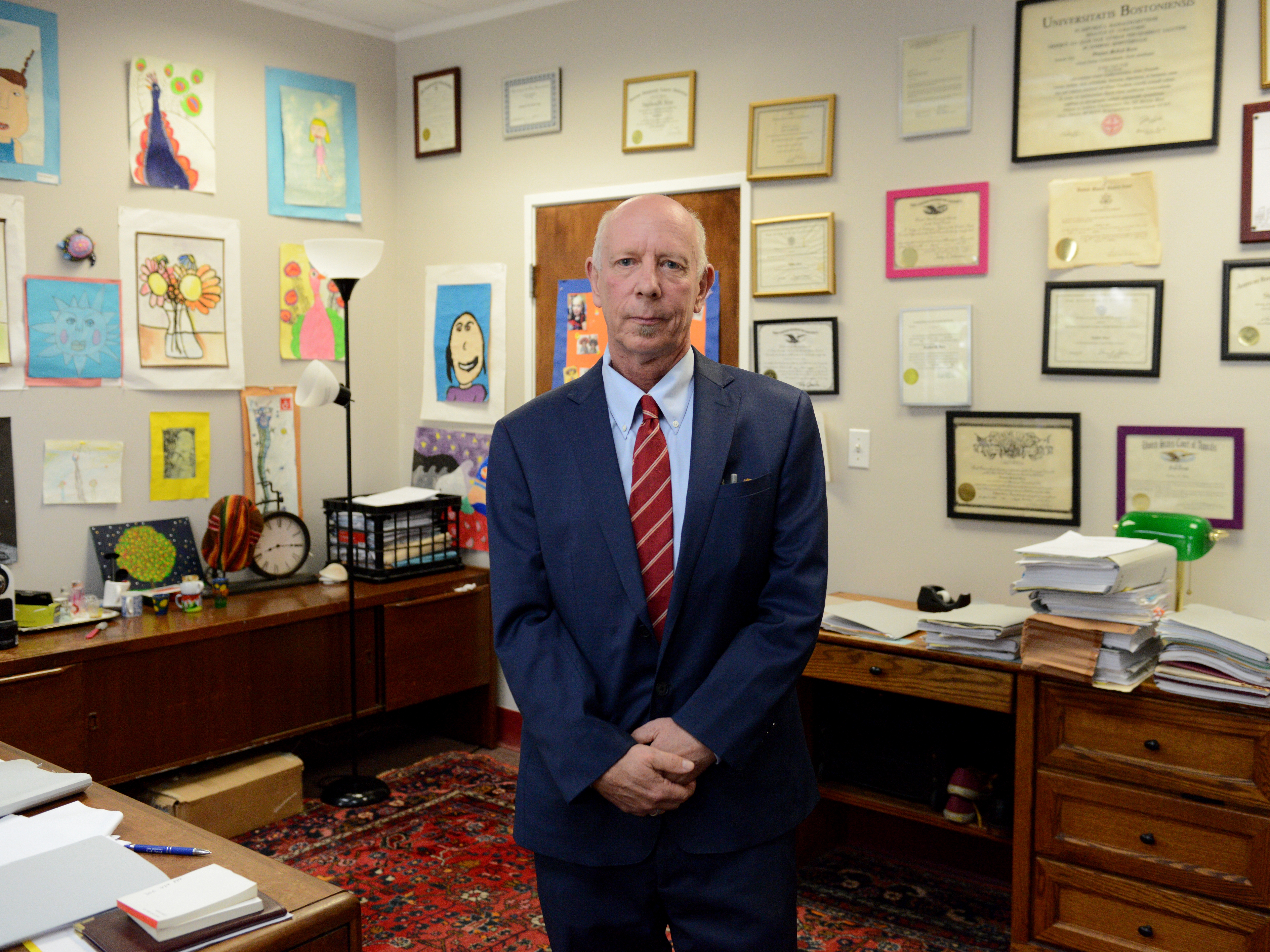 caption: Immigration attorney Stephen Born poses for a photo in his office on July 30, 2025 in Everett, Mass.