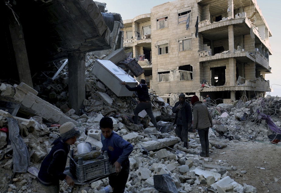 caption: eople remove furniture and household appliances out of a collapsed building after a devastating earthquake rocked Syria and Turkey in the town of Jinderis, Aleppo province, Syria, Tuesday, Feb. 7, 2023. The quake has brought down thousands of buildings and killed thousands of people.