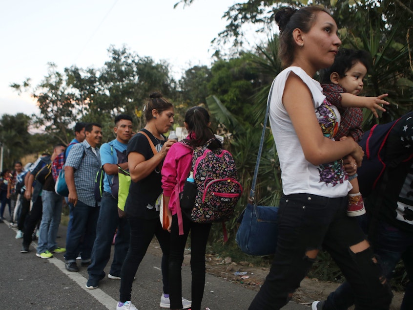 caption: Honduran migrants wait in line to cross over the border checkpoint into Guatemala in Agua Caliente, Honduras. A new caravan of at least several hundred Hondurans has set off toward the United States on foot or in vehicles. Some have already crossed into Guatemala.
