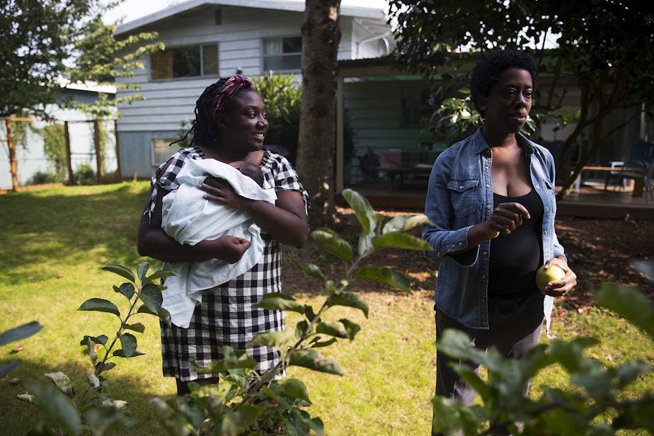 caption: LaTriece Arthur, left, smiles as she holds her newborn son Zoli Rae while picking apples in the backyard with her wife, Christina Arthur, right, on Thursday, October 1, 2020, at their home on Vashon Island.