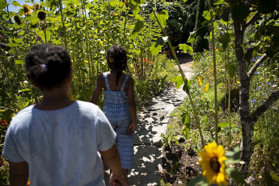 caption: Campers walk through the gardens on Wednesday, July 16, 2025, at the Seattle PlayGarden.