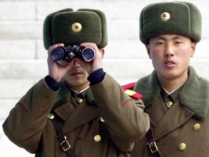 caption: A North Korean soldier looks at the southern side through a pair of binoculars at the border village of Panmunjom, north of Seoul, Wednesday, Feb. 26, 2003.