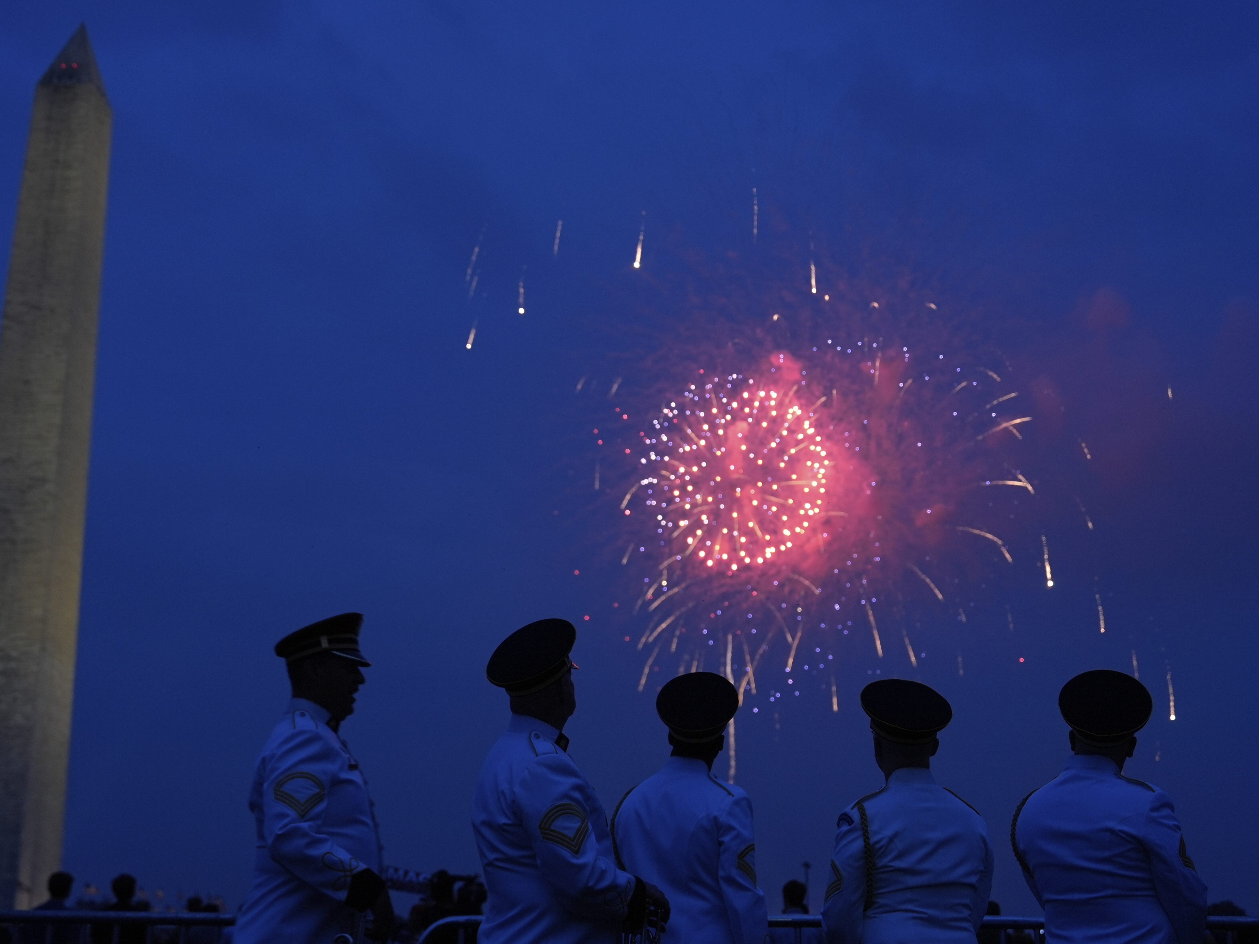 caption: Members of the U.S. Army Band "Pershing's Own" watch fireworks at the end of a military parade commemorating the Army's 250th anniversary on Saturday in Washington, D.C.