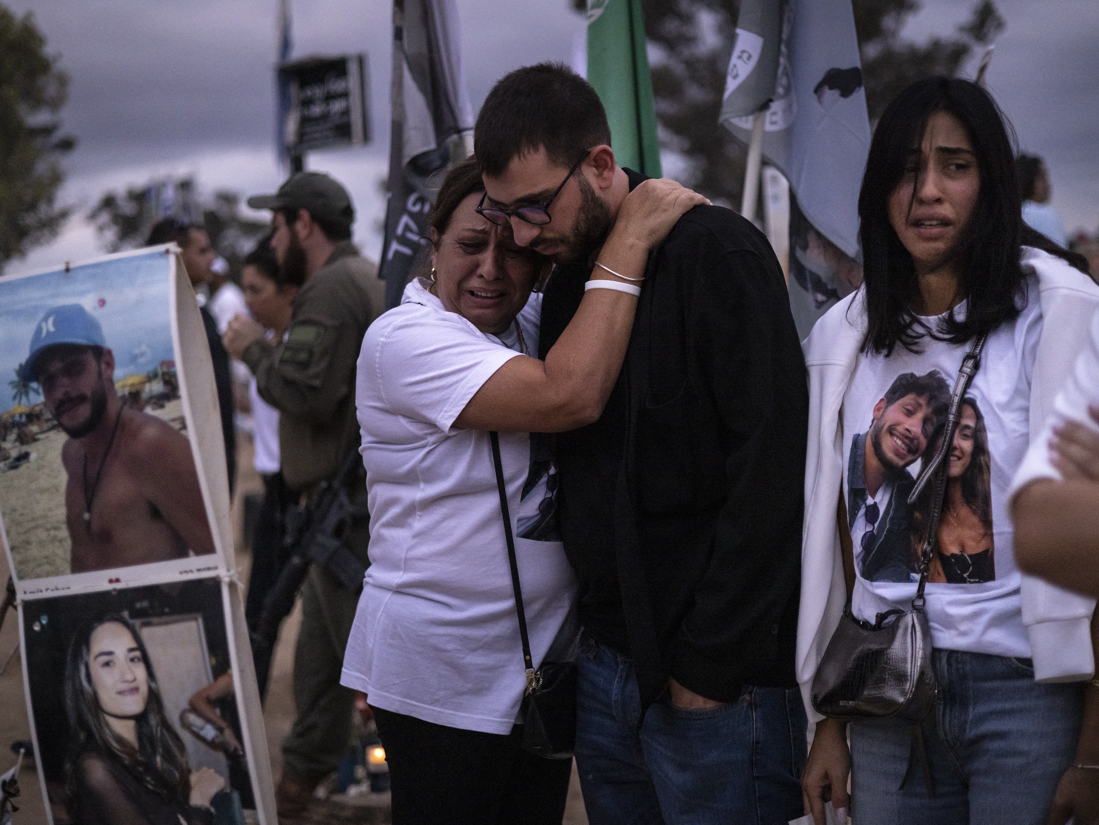 caption: Two people embrace as relatives and supporters of Israelis killed in the Oct. 7, 2023 Hamas attack attend a ceremony at the Nova memorial near Kibbutz Reim in southern Israel on Oct. 7, 2024.