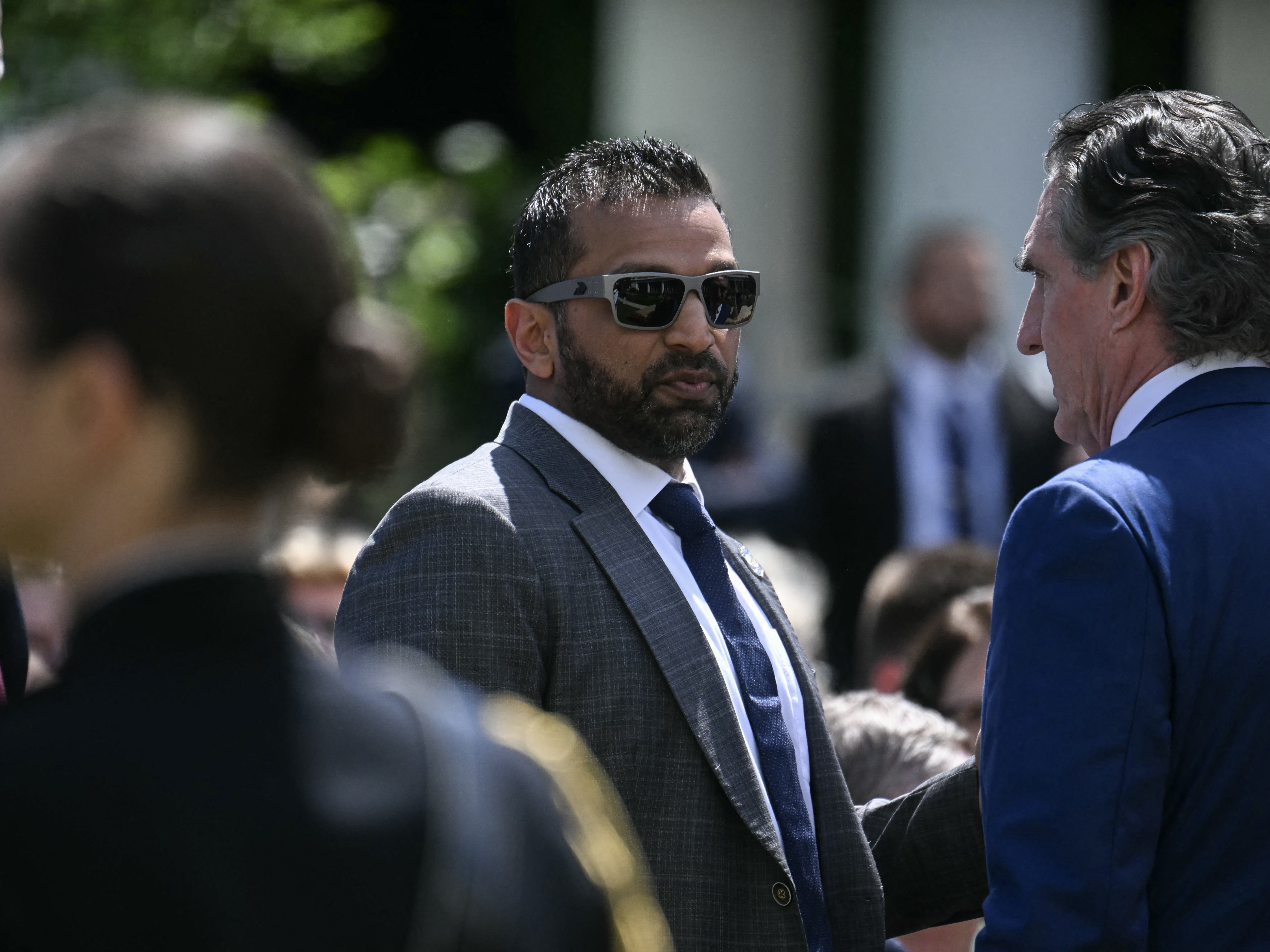 caption: FBI Director Kash Patel speaks with Secretary of the Interior Doug Burgum last month.