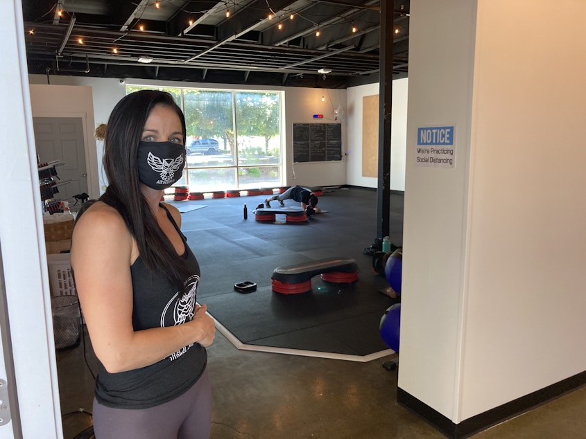 caption: Tiffany Krueger, owner of Athena Fitness and Wellness in Olympia, says the governor's new 17-foot distancing rule for fitness clubs is unfair and could put her out of business.