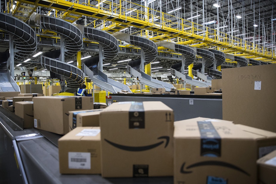 caption: Boxed items are shown on conveyer belts leading to docks where they will be loaded onto trucks at an Amazon fulfillment center on Friday, November 3, 2017, in Kent.