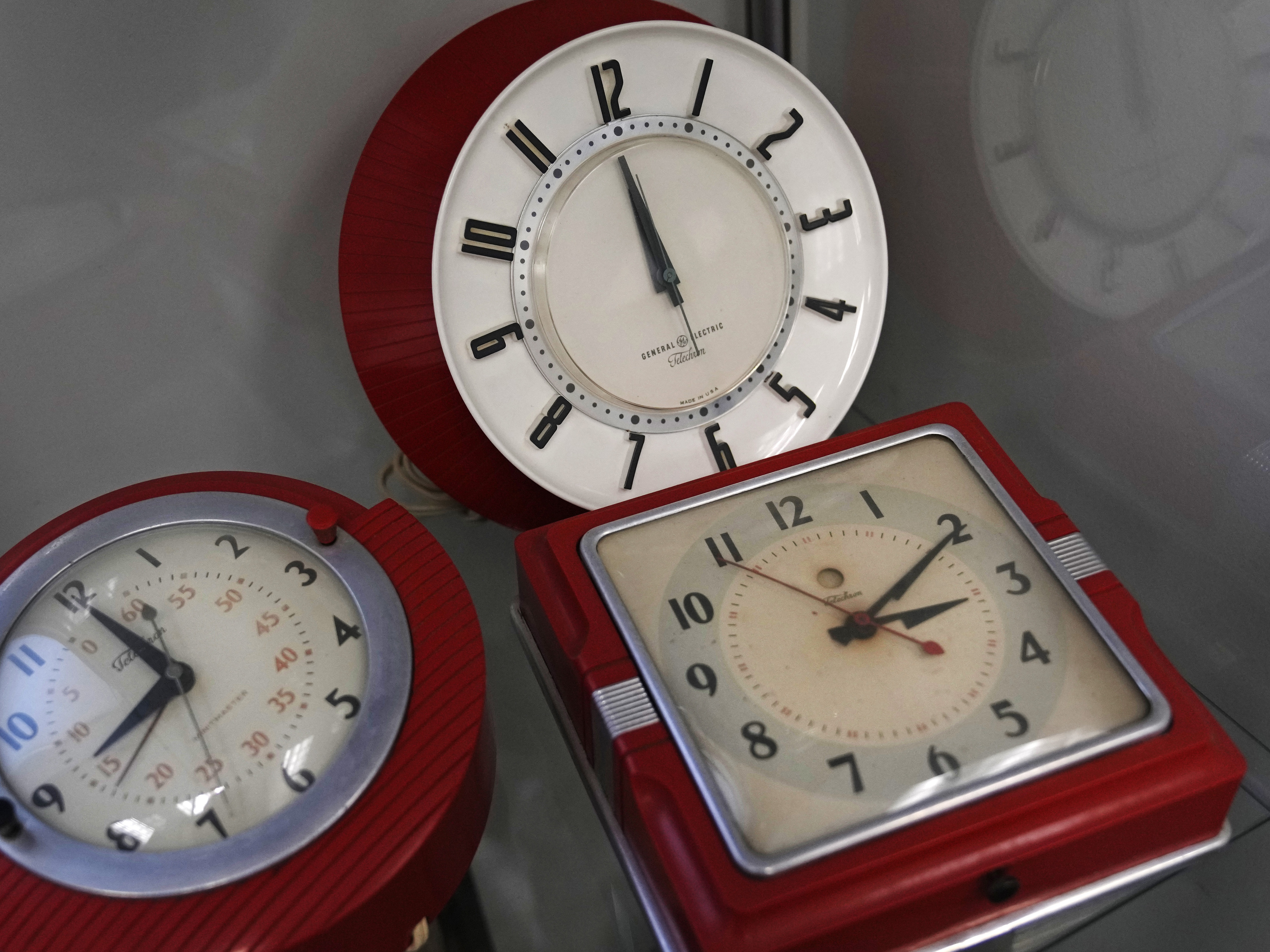 caption: A selection of vintage clocks are displayed at the Electric Time Company, Thursday, March 9, 2023, in Medfield, Mass.
