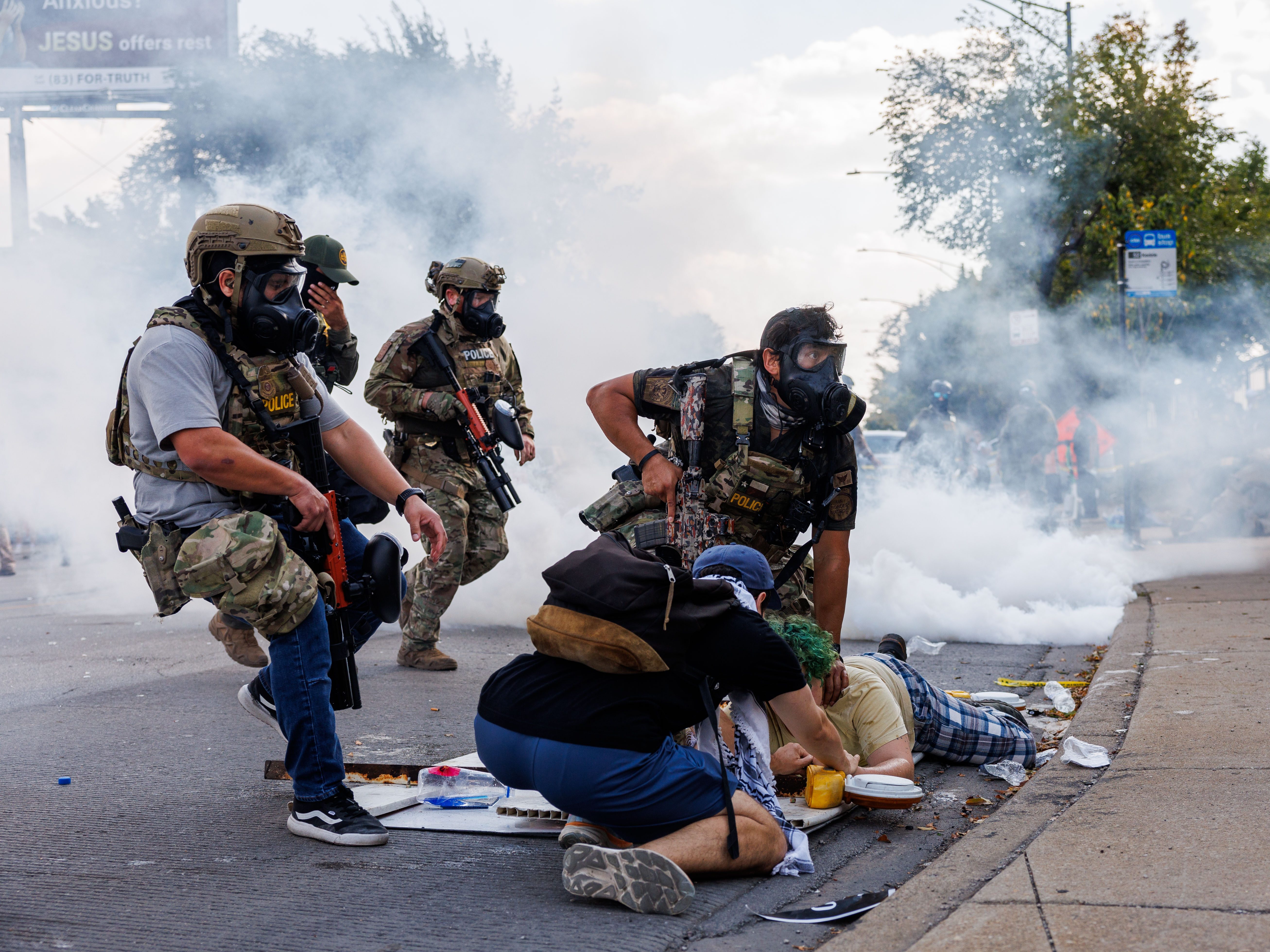 caption: Federal officers detain a person while members of the community and activists protest near the 3900 block of South Kedzie Avenue, Oct. 4, in Chicago.
