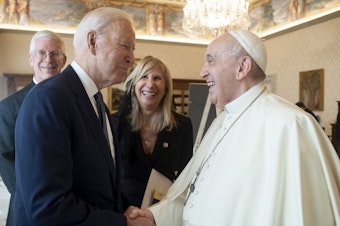 caption: President Biden shakes hands with Pope Francis as they meet at the Vatican on Friday.
