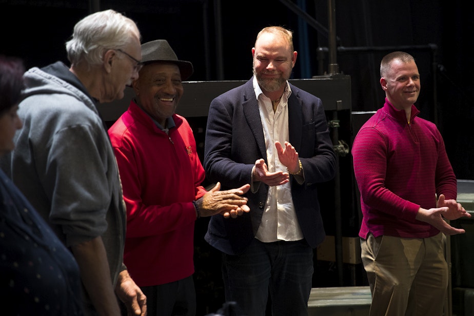 caption: From left, veterans Michael Hammond, Mertiss Thompson, Ryan Mielcarek, and Peter Michaud clap after their final rehearsal presentation on Thursday, October 31, 2019, at Seattle Opera on Mercer Street in Seattle.
