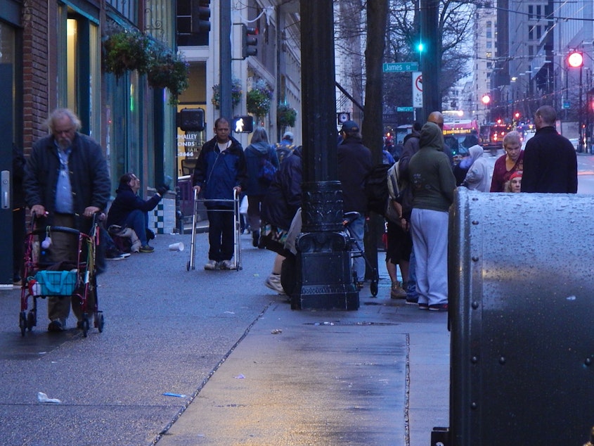 caption: Crowds of homeless people often gather on the sidewalks of downtown Seattle near social-service providers.