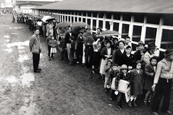 caption: Waiting in line at the mess hall, 1942, Puyallup Assembly Center, Washington State. 