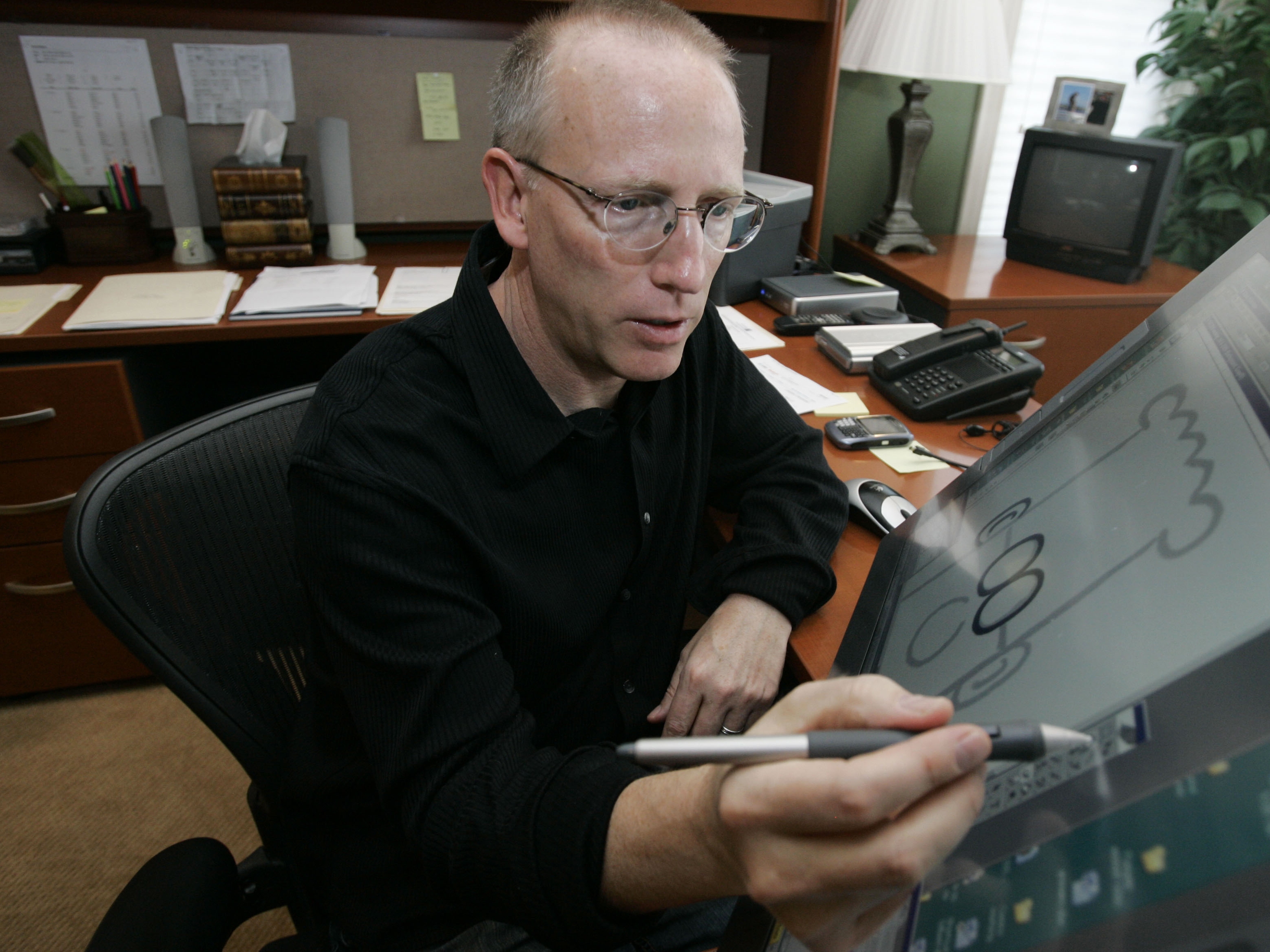 caption: Scott Adams, creator of Dilbert, the office humor comic strip, is pictured at work in 2006. Adams has metastatic prostate cancer and he appealed to President Trump to help save his life by solving a bureaucratic problem with his health insurance. It worked: His appointment is Tuesday.