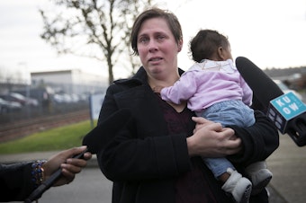 caption: Rebecca Fatty becomes emotional while holding her 4-month-old daughter Sunkarah as she speaks to the press after her husband Bangally Fatty was denied bond on Wednesday, November 29, 2017, at the Northwest Detention Center in Tacoma. 