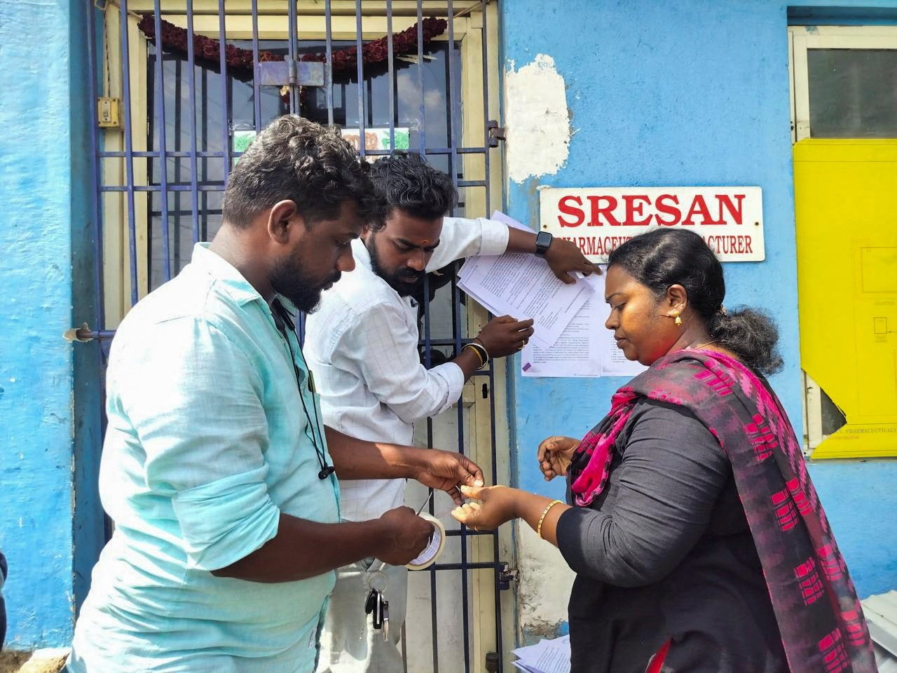 caption: A state health official sticks a notice outside the Sresan Pharmaceutical factory, whose Coldrif cough syrup contained has been linked to the death of children in India.