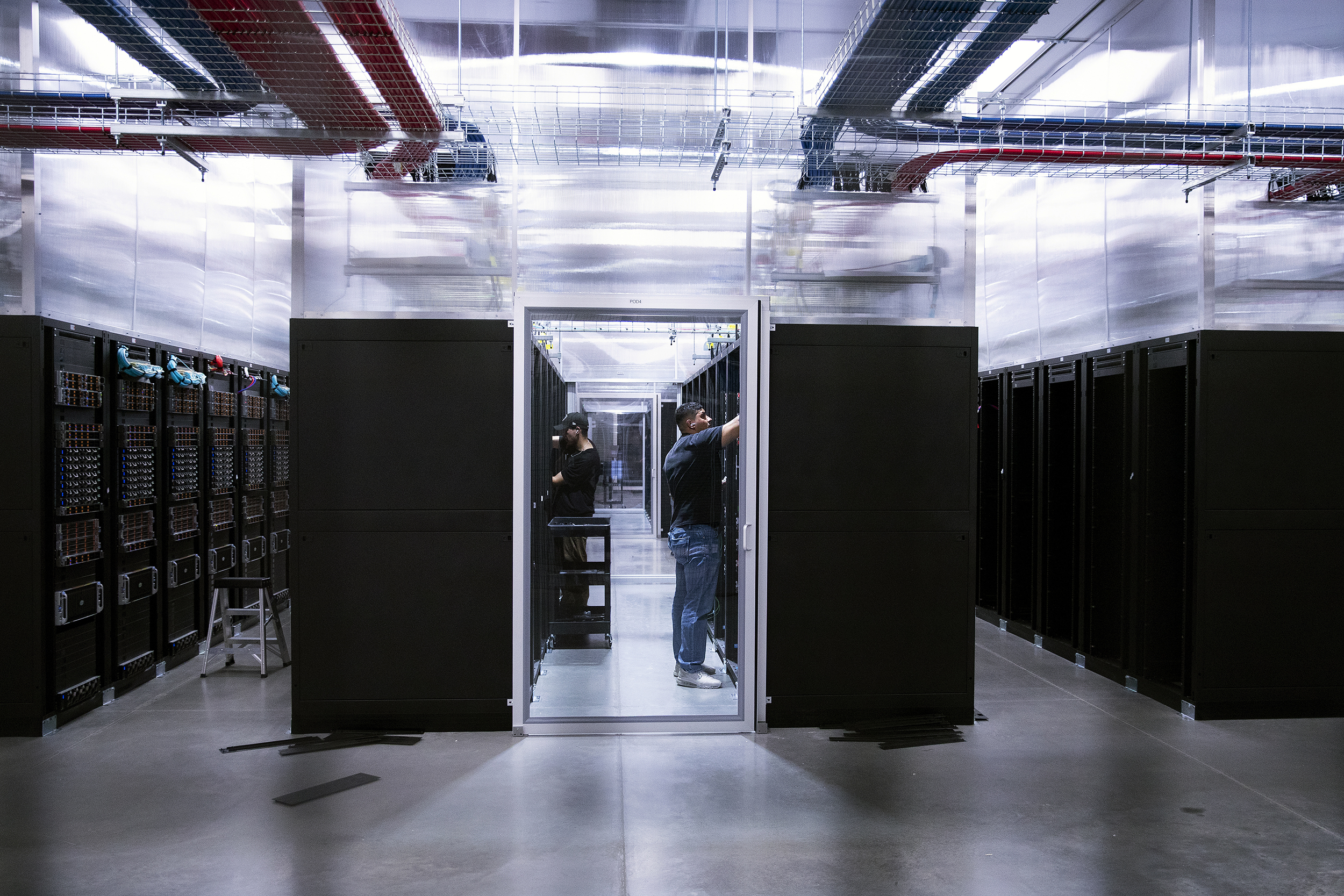 caption: Data center field engineers install new cables on Thursday, July 17, 2025, at the Sabey data center in Quincy, Washington. 