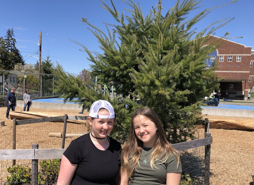 caption: Hawthorne Elementary fourth graders Anna, left, and Francie helped create and maintain a playground that replaced asphalt with new trees. 