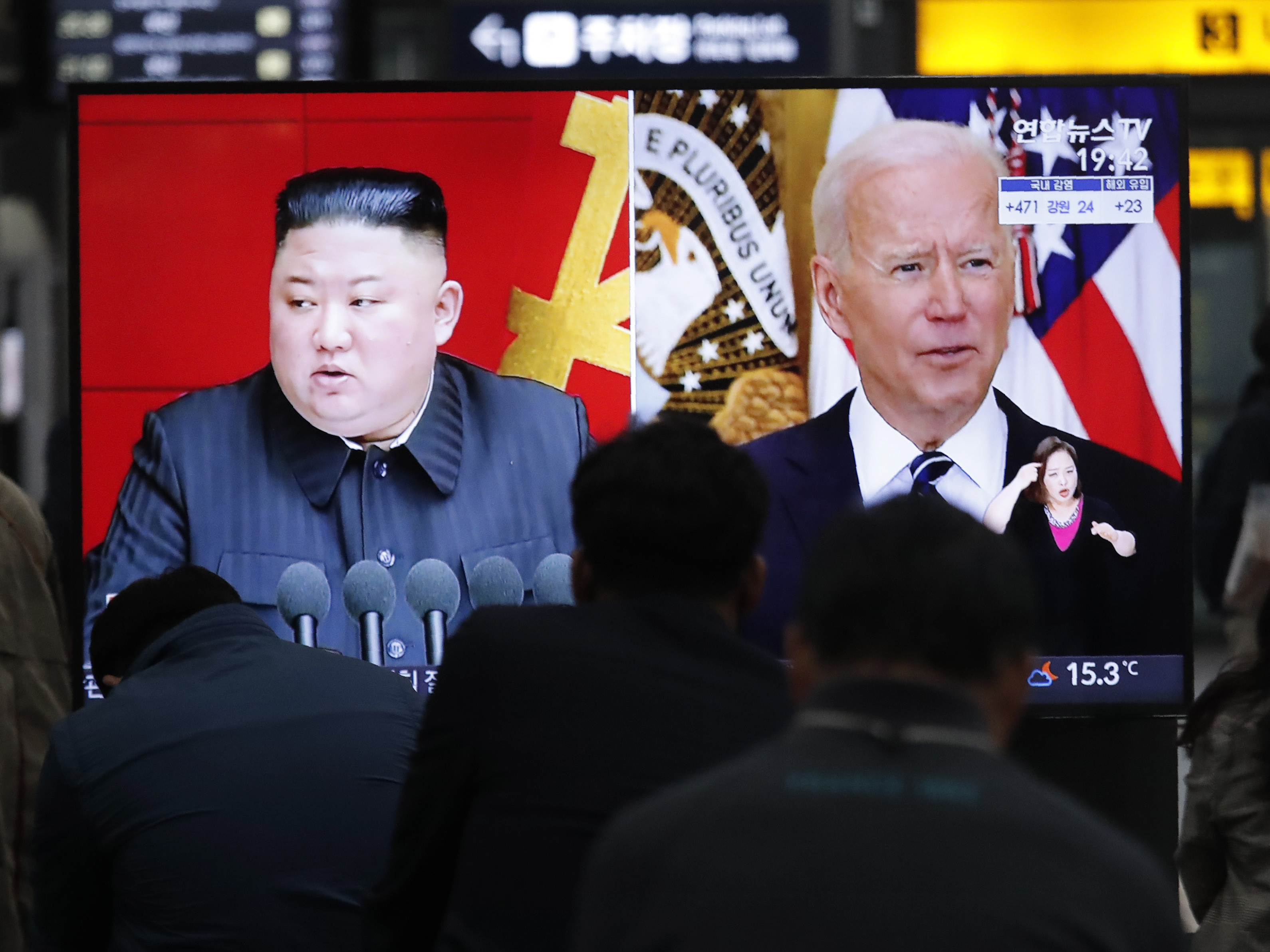 caption: Commuters watch a TV with images of North Korean leader Kim Jong Un and President Biden at a Seoul, South Korea, rail station in March.