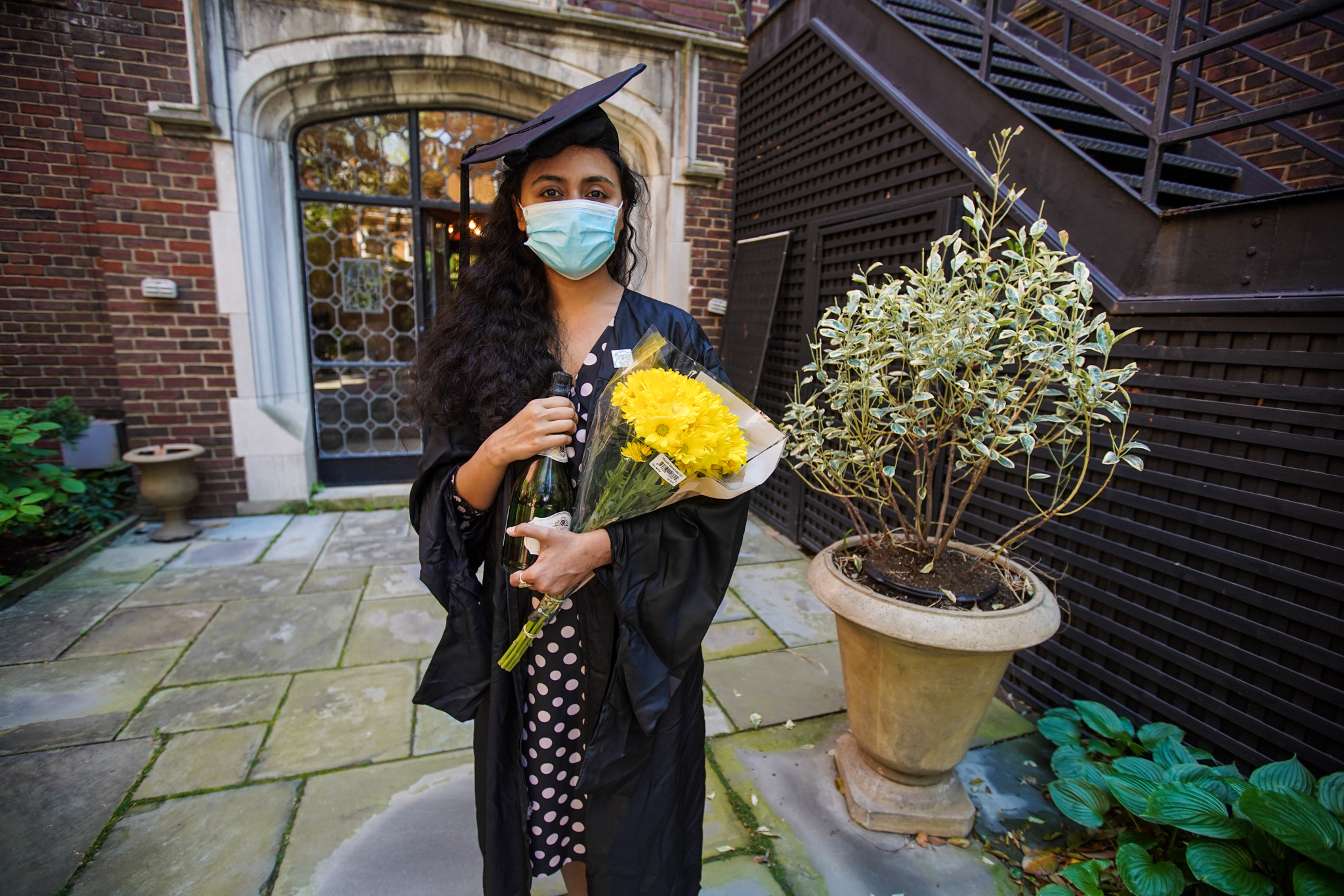 caption: Pakistani student Varsha Thebo, 27, poses on the campus of the International Student House where she resides, on the day of her graduation from Georgetown University in Washington, DC on May 15, 2020. (AGNES BUN/AFP via Getty Images)