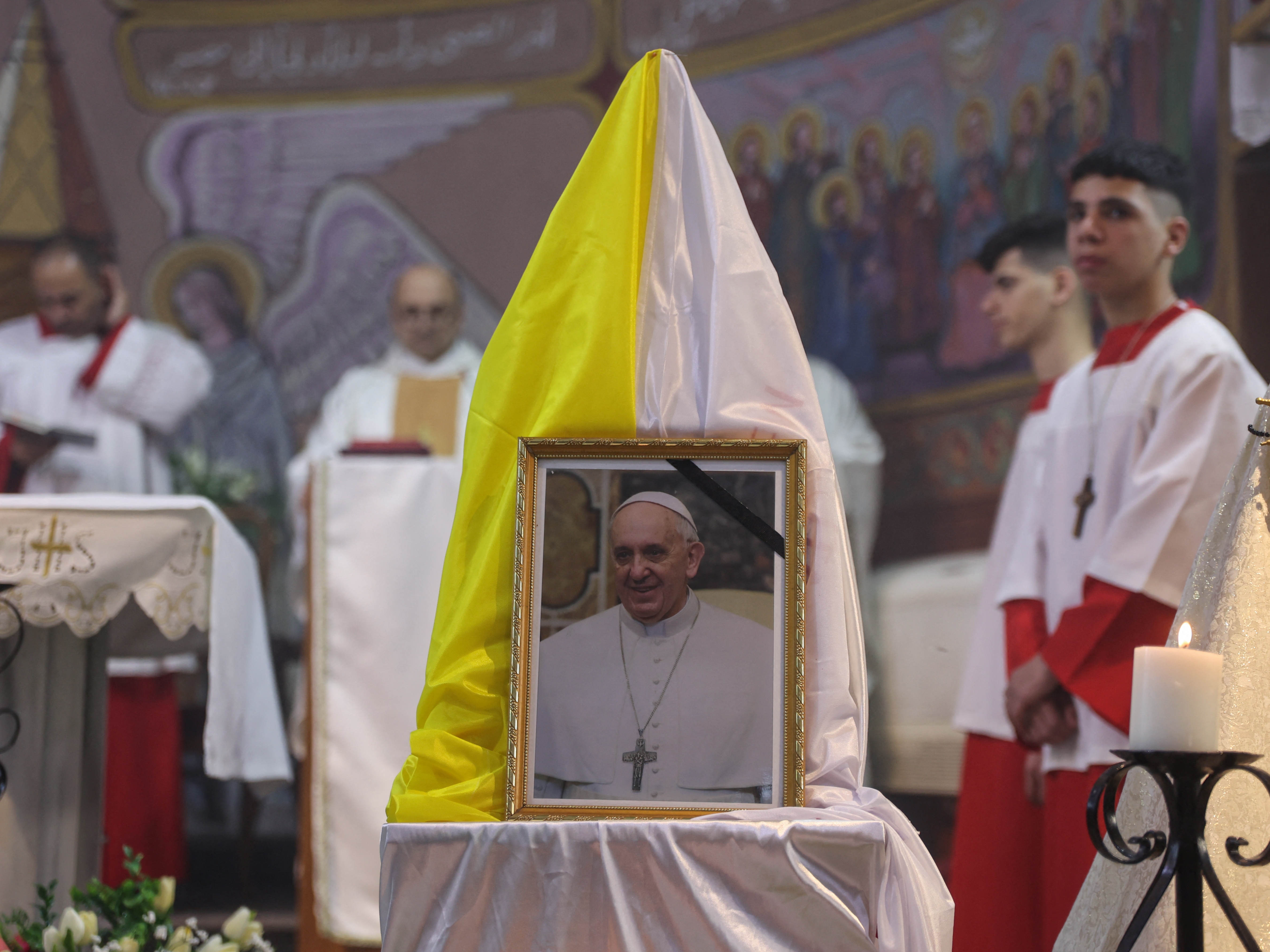 caption: Members of the clergy celebrate Mass for the late Pope Francis at the Holy Family Church in Gaza City on Monday.