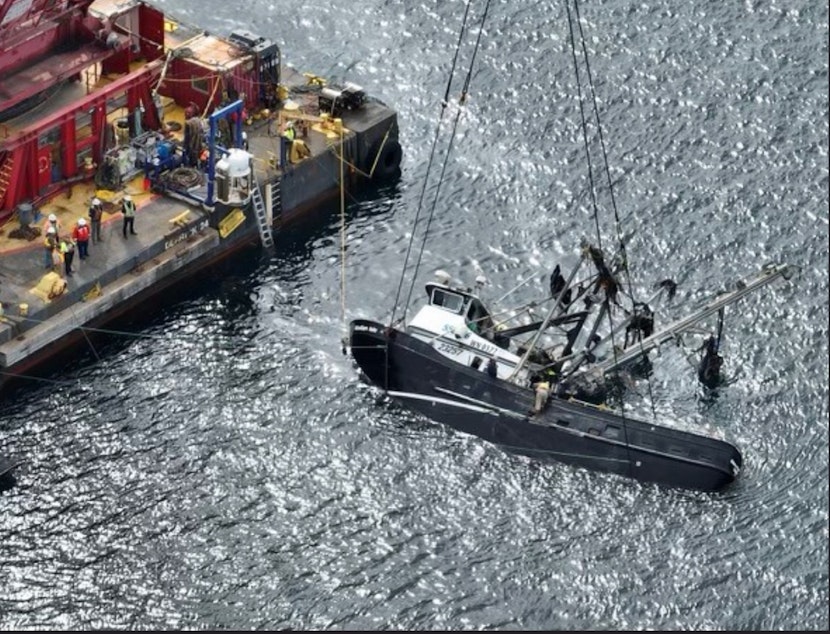 caption: A diesel sheen spreads from the Aleutian Isle, newly lifted to the surface by a crane Sept. 17, 2022, five weeks after sinking off San Juan Island.