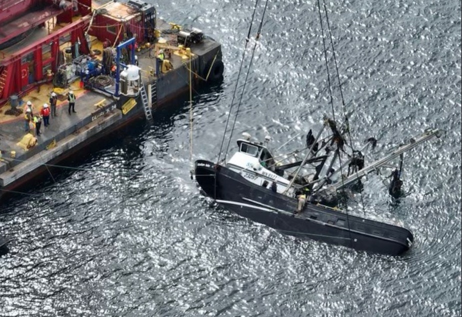 caption: A diesel sheen spreads from the Aleutian Isle, newly lifted to the surface on by a crane Sept. 17, five weeks after sinking off San Juan Island.