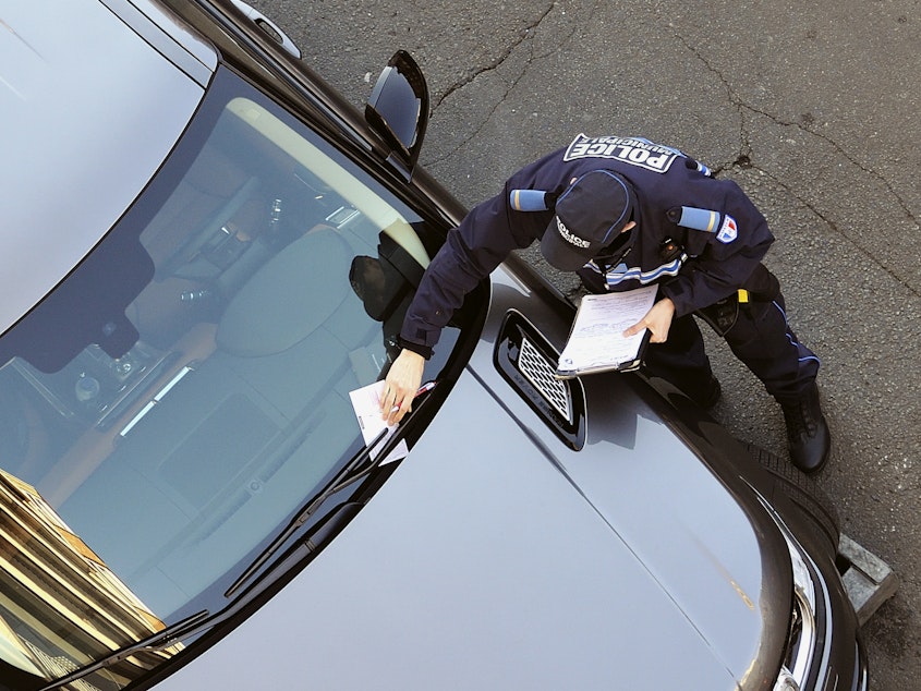 caption: A policeman issues a parking ticket in this 2013 photo. A federal appeals court held Monday that using chalk to mark tires for purposes of parking enforcement violates the U.S. Constitution.