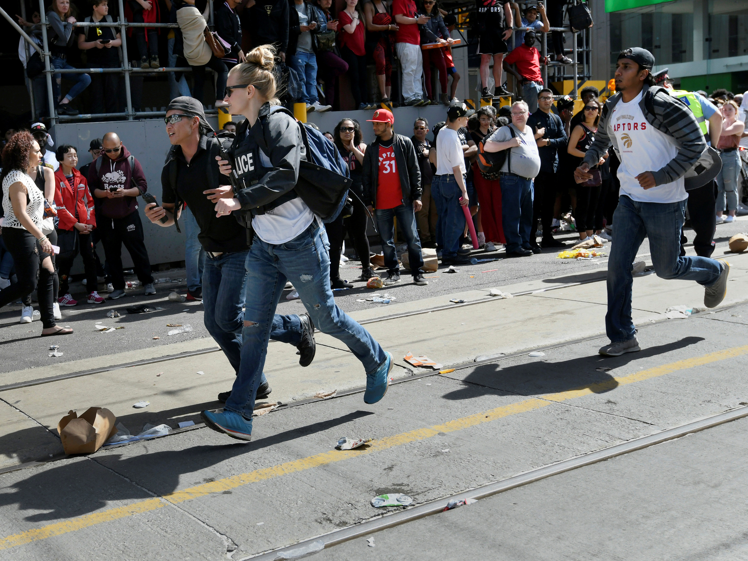 caption: Crowds scatter after reports of shots fired in Nathan Phillips Square in Toronto in June. Tens of thousands of people were gathered in the area to celebrate the Toronto Raptors' victory parade. By the end of 2019, more than 760 people had been shot in the city, 44 of whom were killed, according to Toronto Police.
