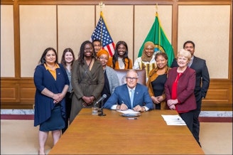 caption: Washington state Gov. Jay Inslee and supporters of Senate Bill 5453 against female genital mutilation at the bill's signing in 2023. 