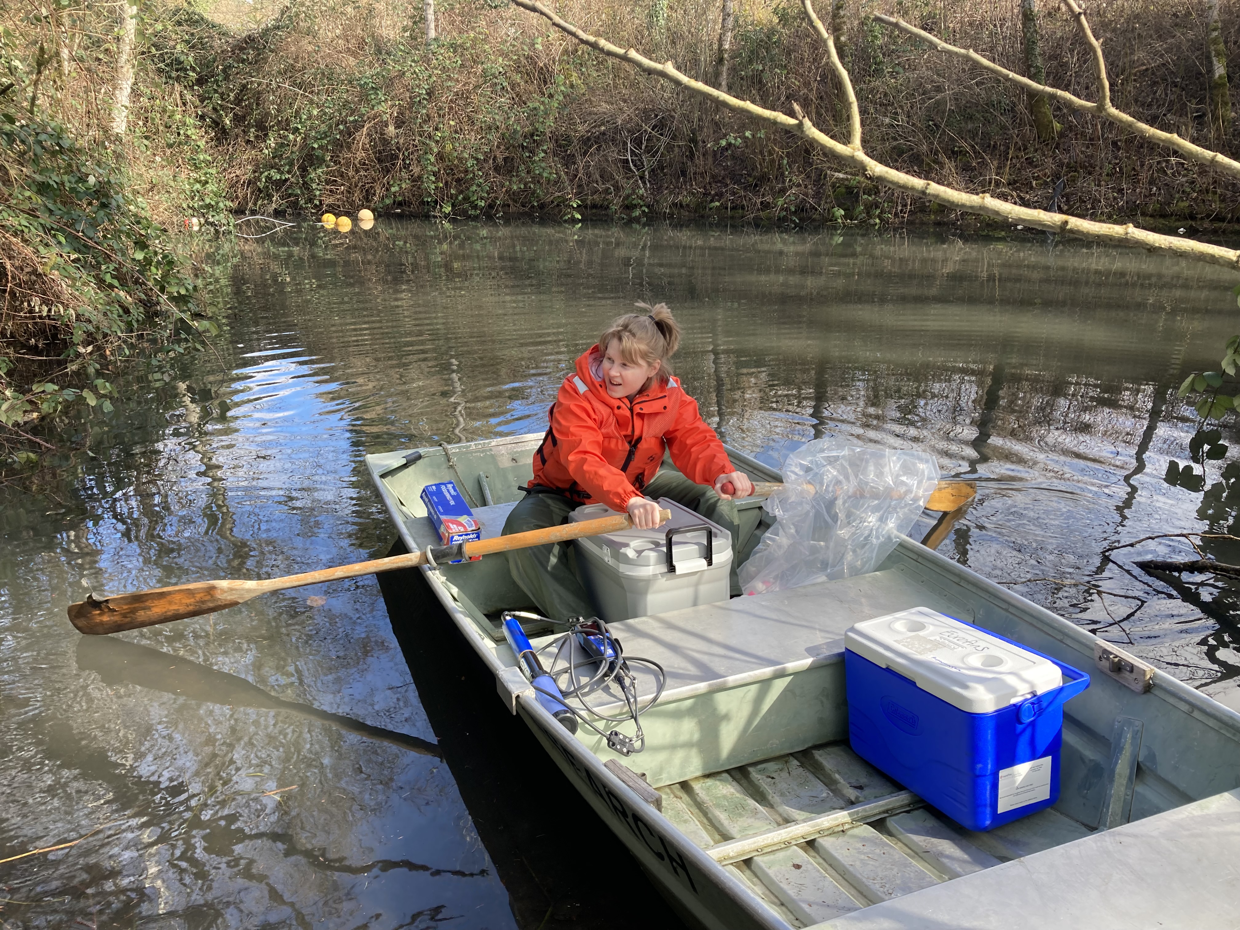 caption: Natural resource scientist Katelyn Foster with the Washington Department of Ecology rows in a stream in Olympia to collect samples to check for the presence of 6PPD-Q from tire rubber runoff.