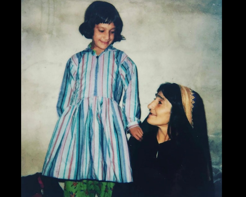 caption: Zarby Kakar with her mother, Addie, who stayed up all night sewing a new dress for her before coming to the United States. "I was so proud to wear that dress," said Kakar. 