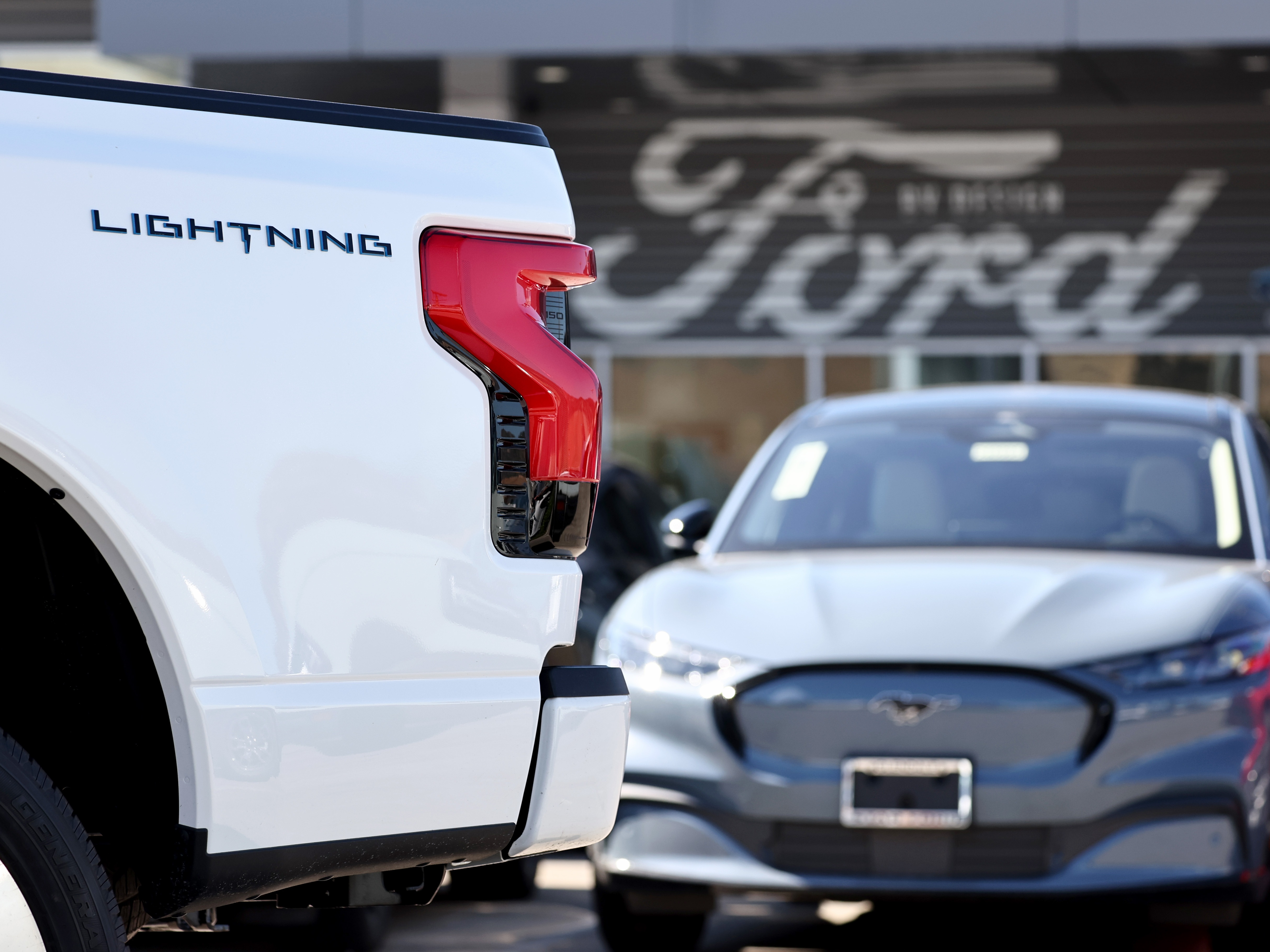 caption: A Ford F-150 Lightning electric pickup truck is displayed for sale at a Ford dealership on Aug. 21 in Glendale, Calif. Ford says it is upending its electric vehicle strategy for North American vehicles to focus on hybrids, citing consumers' demands for affordability and longer ranges.