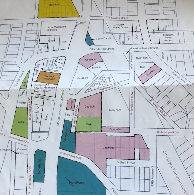 caption: In a 3 ring binder, the Rainier Beach Action Coalition tracks ownership of properties near the light rail station at S Henderson and Martin Luther King Jr. Way S.