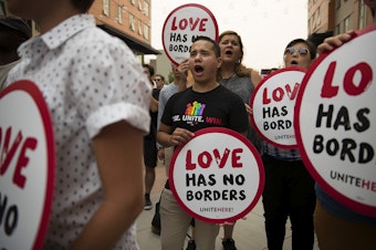 caption: Emmanuel Carrillo, center, with UNITE HERE, the Hospitality Worker's Labor Union, chants during a community rally in support of DACA recipients on Tuesday.