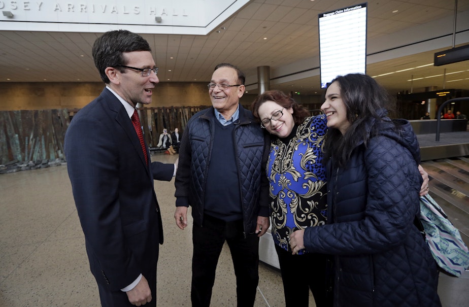 caption: Attorney General Bob Ferguson, left, greets Allen Novak, newly-arrived from Iran, his wife Jayne and their daughter Nikta Monday, Feb. 6, 2017, at Sea-Tac Airport. Allen Novak joined his family, of Silverdale, Wash., on a conditional resident visa.
