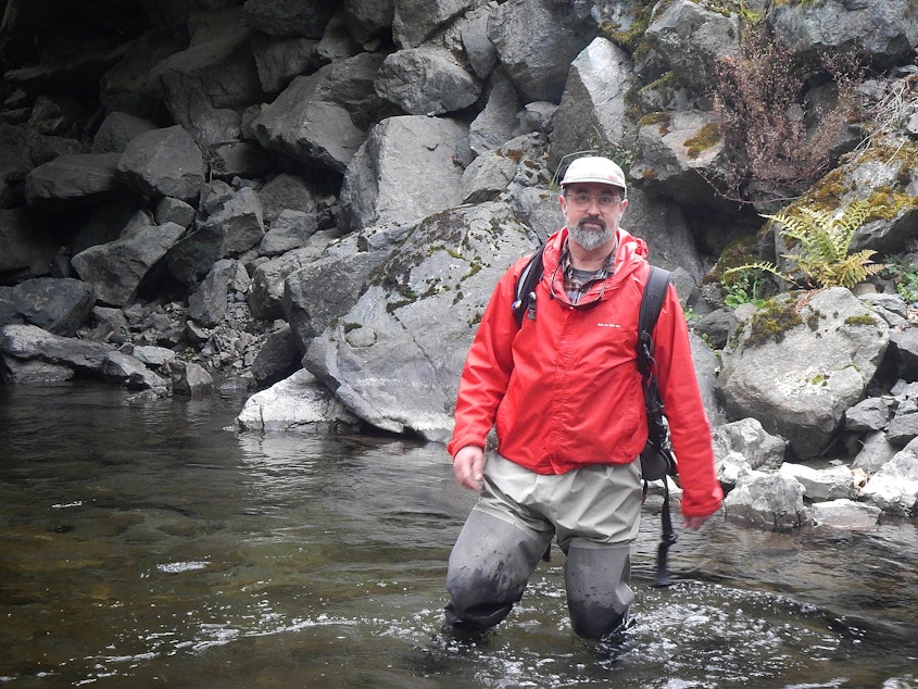 caption: Biologist Jon-Paul Shannahan standing in front of habitat-smothering riprap along Grandy Creek in the Skagit basin.