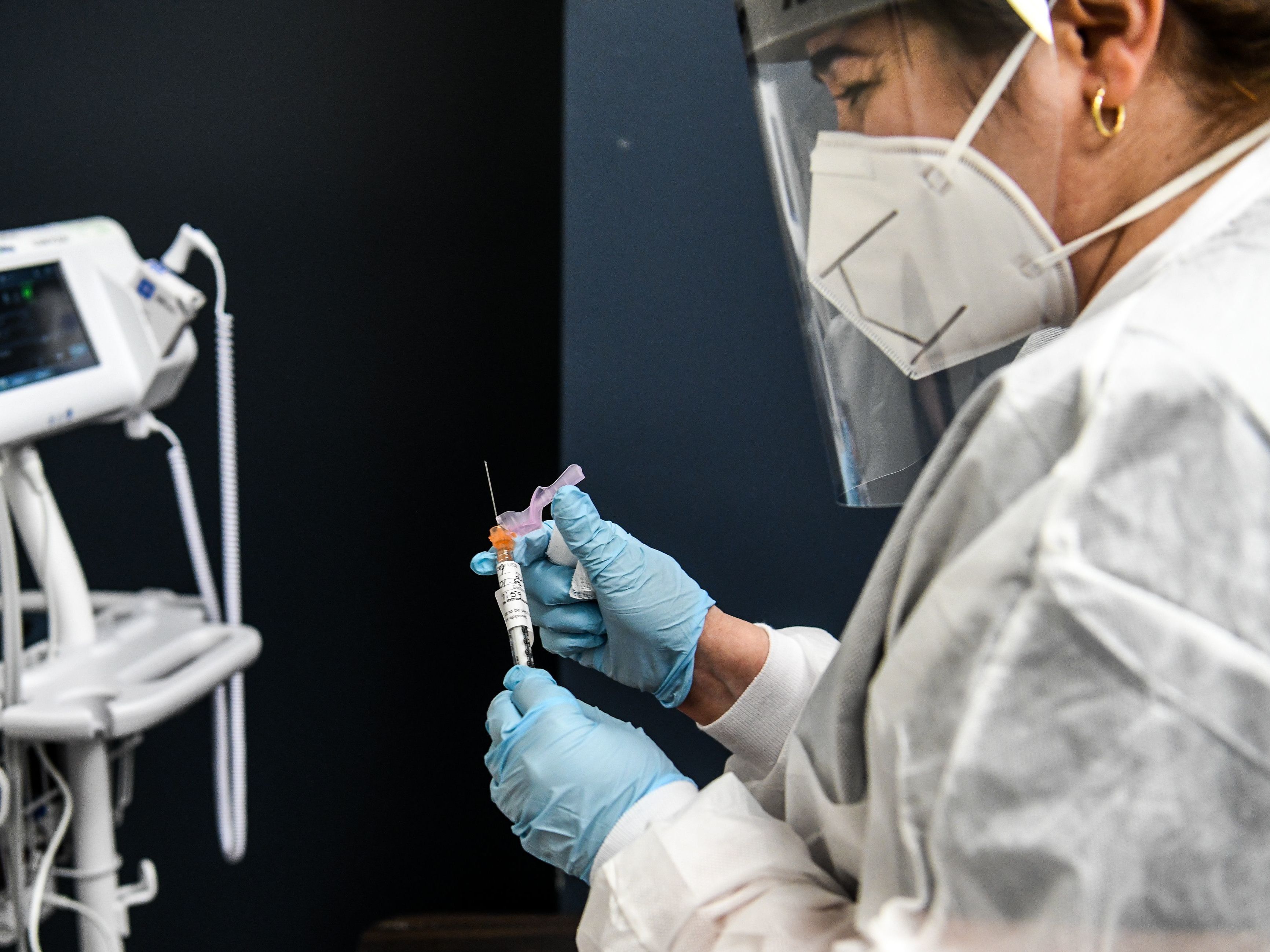 caption: Yaquelin De La Cruz holds a COVID-19 vaccine during clinical trials in August at the Research Centers of America in Hollywood, Fla.