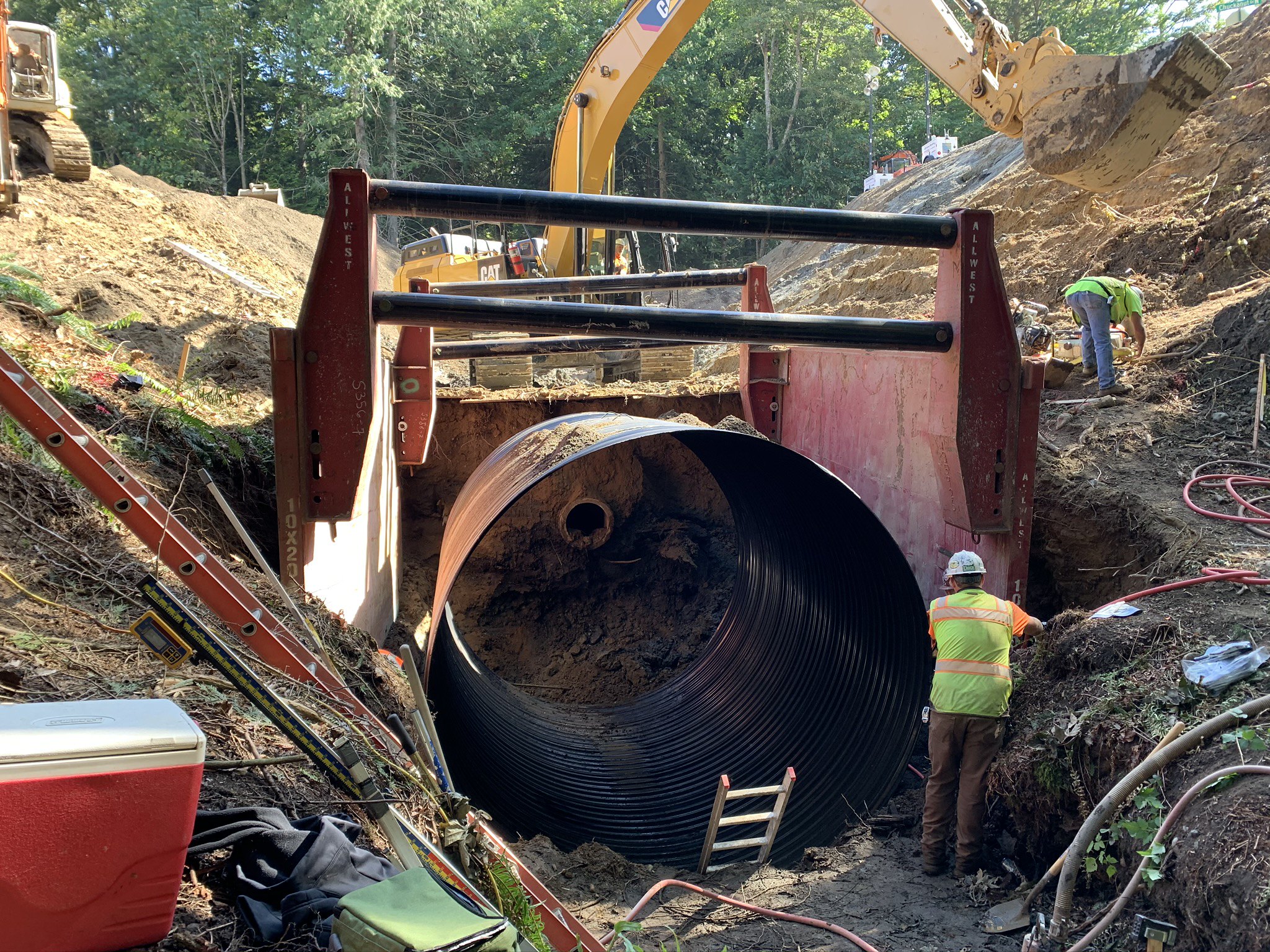 caption: Crews in Bellingham replace an old culvert (center) with a new 12-foot diameter pipe. The old culvert was too smalland sat too high for juvenile fish to navigate during their migration to their spawning grounds.