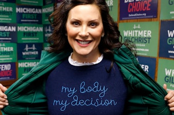 caption: Michigan State Governor Gretchen Whitmer shows a "My Body My Decision" shirt at the 14th District Democratic Headquarters in Detroit, Michigan, on November 8, 2022.